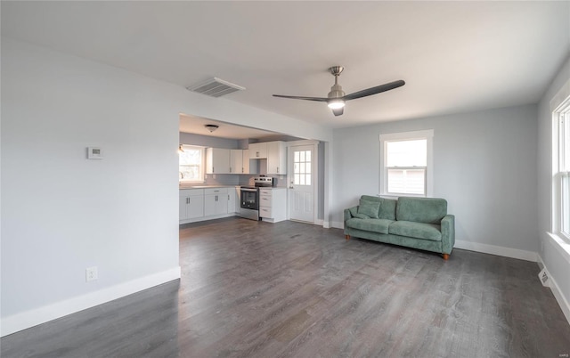 unfurnished living room with dark hardwood / wood-style flooring and ceiling fan