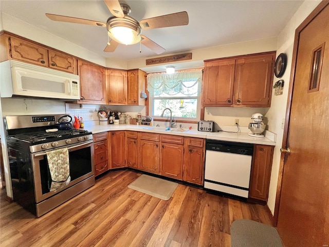 kitchen with hardwood / wood-style floors, white appliances, sink, ceiling fan, and tasteful backsplash