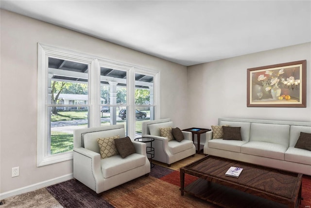 living room featuring dark wood-type flooring and a wealth of natural light