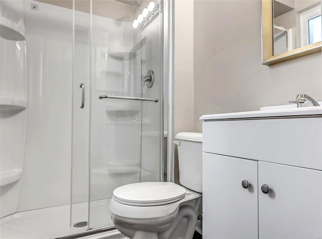 bathroom with vanity, toilet, and a shower with shower door