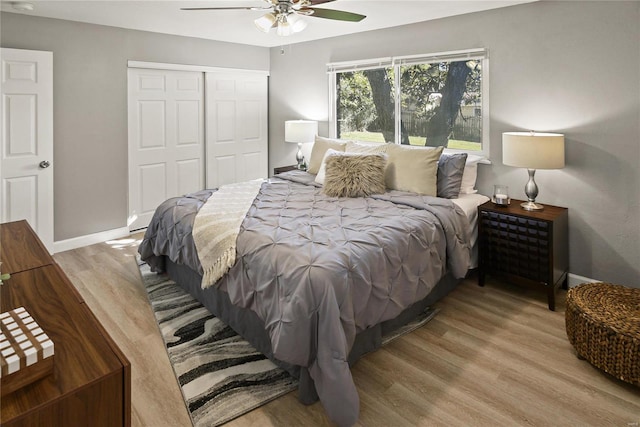 bedroom with light hardwood / wood-style floors, a closet, and ceiling fan