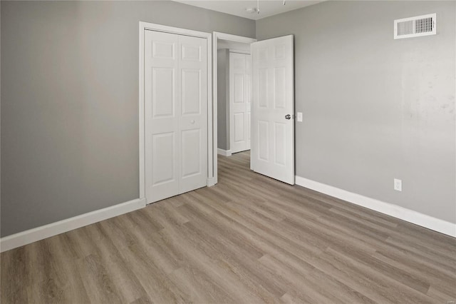 unfurnished bedroom featuring a closet and light wood-type flooring