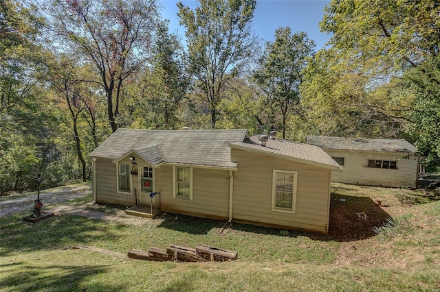 rear view of property featuring a yard