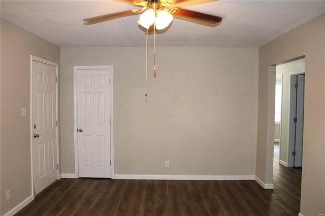 empty room with ceiling fan and dark wood-type flooring