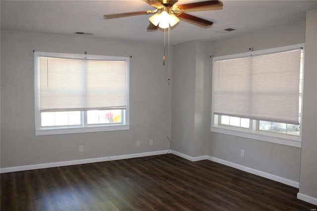 unfurnished room with ceiling fan, plenty of natural light, and dark wood-type flooring