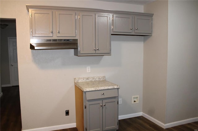 kitchen featuring dark wood-type flooring, range hood, and gray cabinets