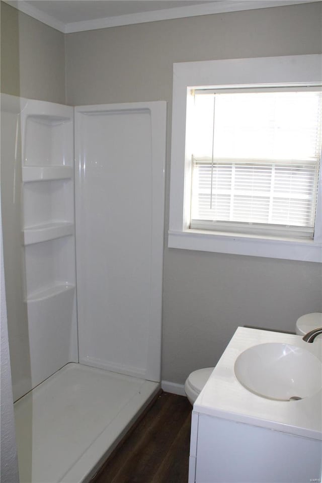 bathroom with walk in shower, toilet, crown molding, hardwood / wood-style floors, and vanity