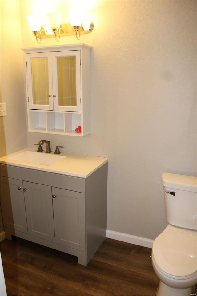 bathroom with wood-type flooring, vanity, and toilet