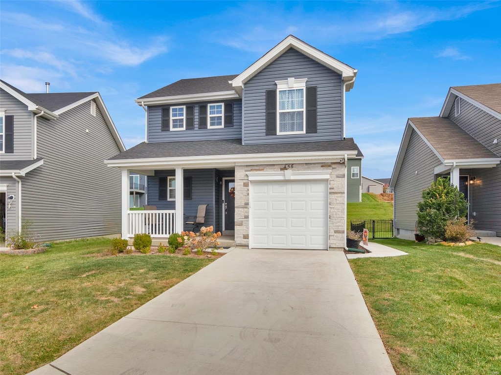 view of front of home with a garage, a front yard, and a porch