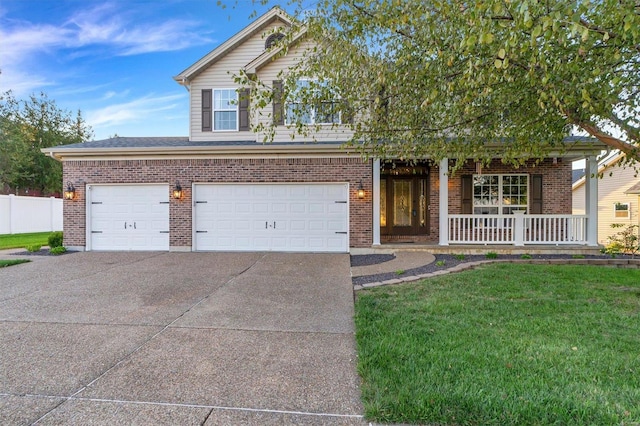 view of front of house with a front lawn, covered porch, and a garage