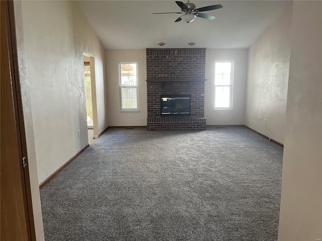 unfurnished living room featuring ceiling fan, a fireplace, carpet, and a healthy amount of sunlight