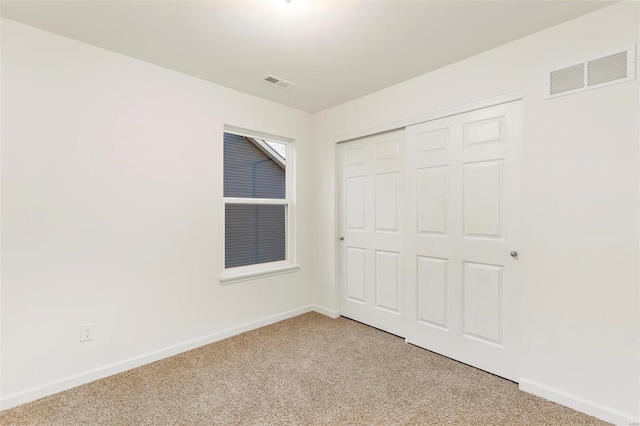 unfurnished bedroom with light carpet and a closet