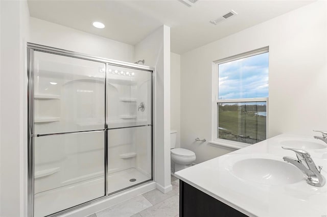 bathroom with vanity, toilet, a shower with door, and tile patterned floors