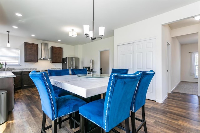 dining space with a notable chandelier, sink, and dark hardwood / wood-style flooring