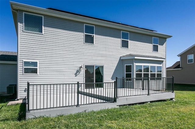 rear view of property with a yard and a deck