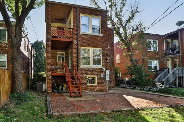 rear view of house with a balcony, cooling unit, and a patio