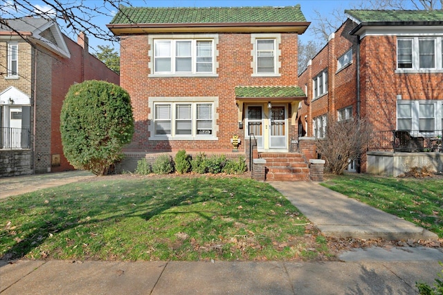 view of front of home with brick siding and a front lawn