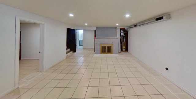 unfurnished living room with a brick fireplace and light tile patterned floors