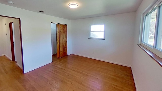 unfurnished bedroom with a closet and light hardwood / wood-style flooring