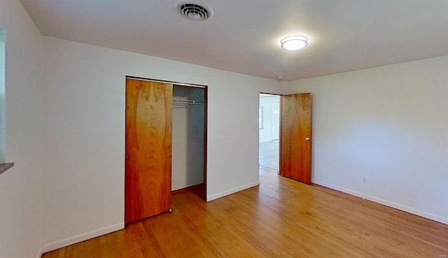 unfurnished bedroom featuring a closet and light hardwood / wood-style floors