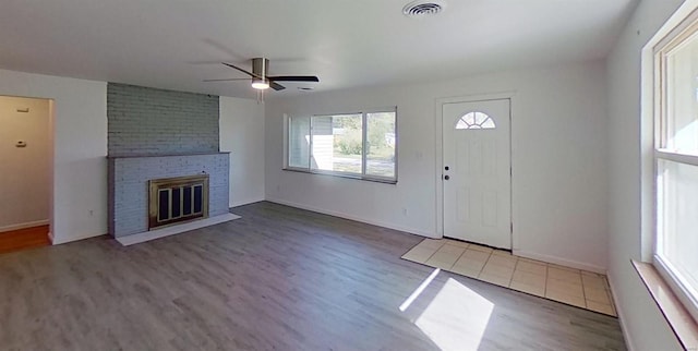 foyer with a fireplace, ceiling fan, and hardwood / wood-style floors