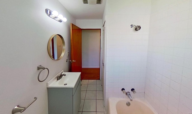 bathroom with tile patterned flooring, vanity, and tiled shower / bath combo