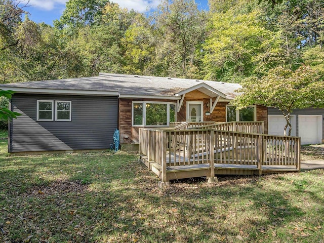 back of house featuring a wooden deck, a lawn, and a garage