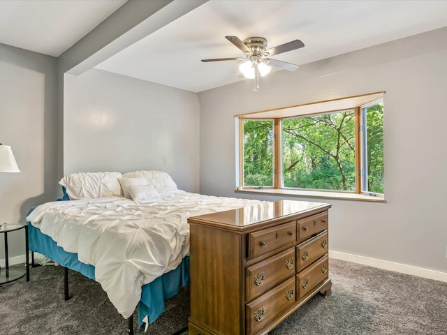 bedroom with ceiling fan, beam ceiling, and dark colored carpet