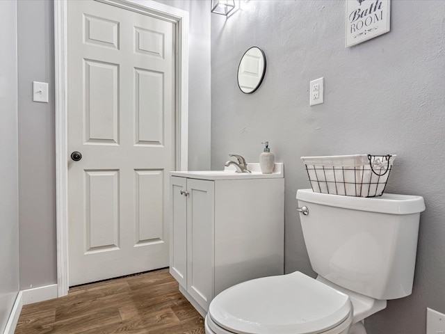 bathroom with vanity, toilet, and wood-type flooring