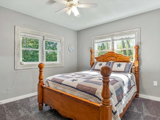 bedroom with dark colored carpet, multiple windows, and ceiling fan