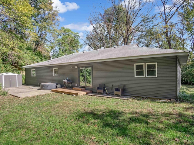 rear view of property with a storage shed, a yard, and a wooden deck