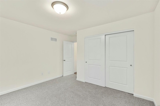 unfurnished bedroom featuring a closet and light carpet