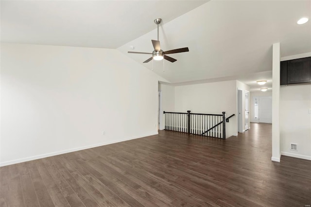 empty room featuring ceiling fan, vaulted ceiling, and dark hardwood / wood-style flooring