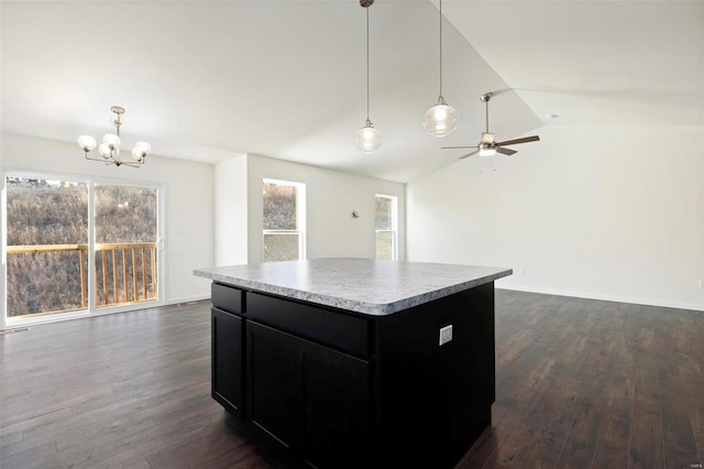 kitchen featuring lofted ceiling, decorative light fixtures, a kitchen island, and dark hardwood / wood-style flooring