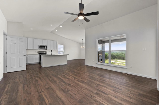 kitchen with a kitchen island with sink, vaulted ceiling, dark hardwood / wood-style floors, appliances with stainless steel finishes, and white cabinetry