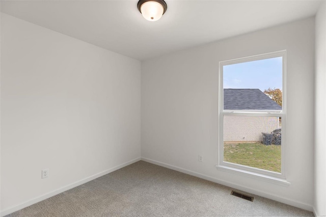 carpeted spare room featuring plenty of natural light