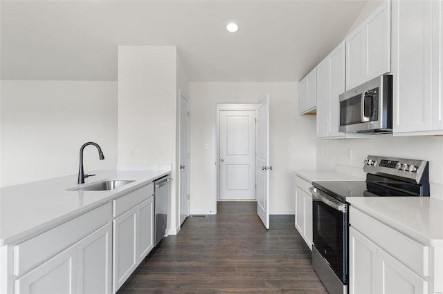 kitchen featuring appliances with stainless steel finishes, sink, dark hardwood / wood-style flooring, and white cabinetry