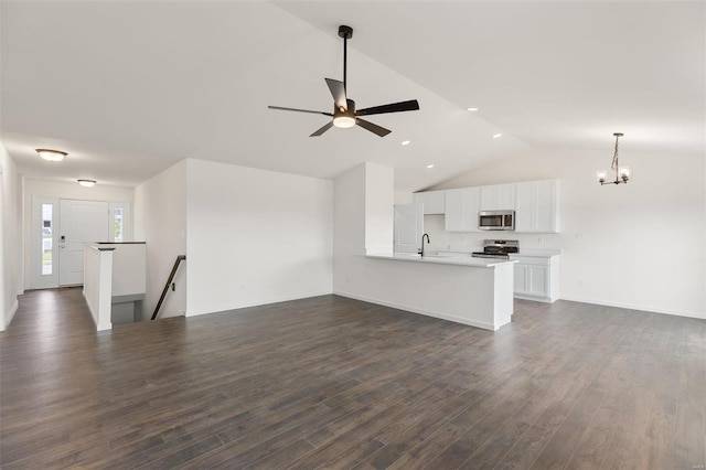 unfurnished living room with dark wood-type flooring, ceiling fan with notable chandelier, vaulted ceiling, and sink