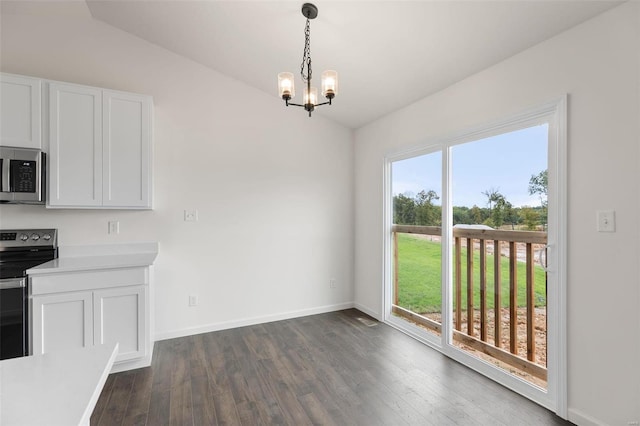 unfurnished dining area featuring dark hardwood / wood-style floors, vaulted ceiling, a notable chandelier, and a healthy amount of sunlight