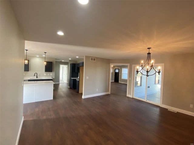 interior space featuring a notable chandelier, hanging light fixtures, sink, and dark hardwood / wood-style floors