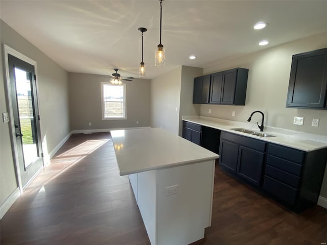 kitchen with pendant lighting, a center island, sink, and dark hardwood / wood-style flooring