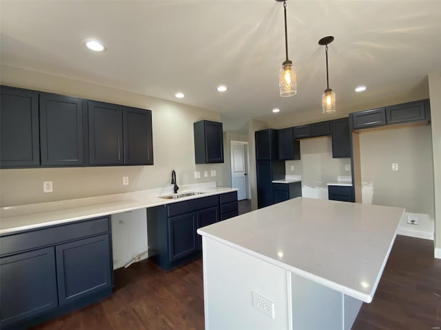 kitchen featuring a kitchen island, pendant lighting, sink, and dark hardwood / wood-style flooring