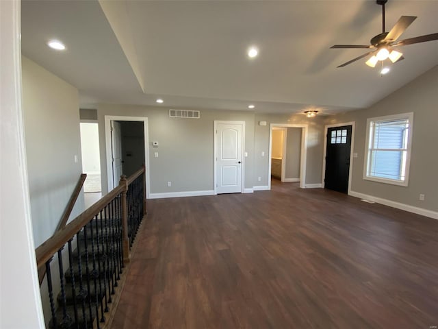 empty room with ceiling fan, vaulted ceiling, and dark hardwood / wood-style flooring