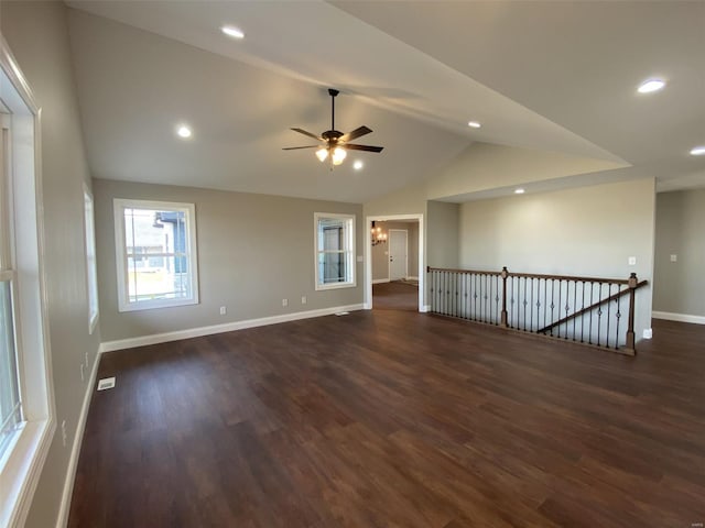 unfurnished room with lofted ceiling, ceiling fan, and dark hardwood / wood-style flooring