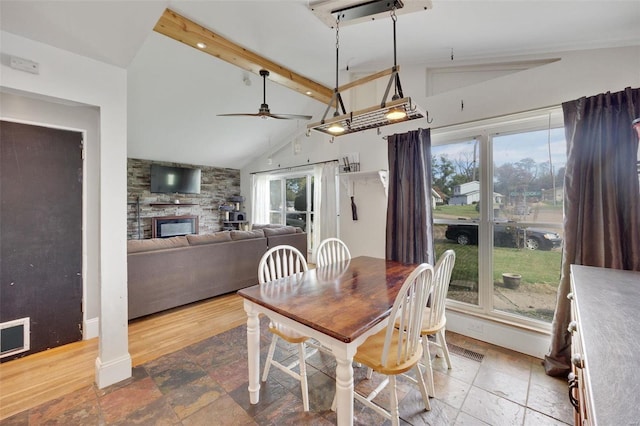 dining room featuring ceiling fan, vaulted ceiling with beams, and a healthy amount of sunlight