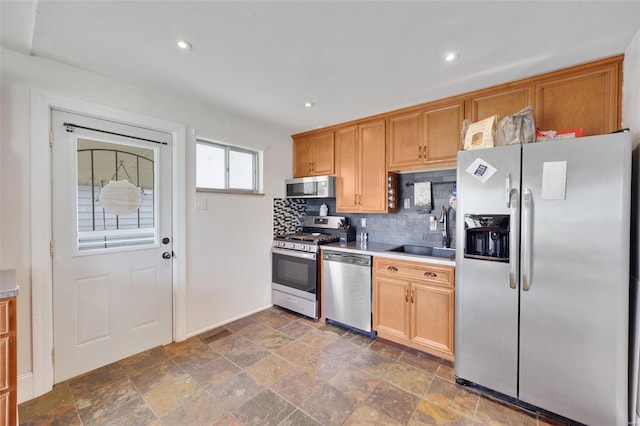 kitchen featuring backsplash, appliances with stainless steel finishes, and sink