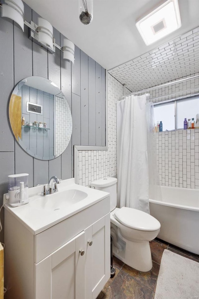 full bathroom featuring vanity, tile walls, shower / bath combo with shower curtain, and toilet