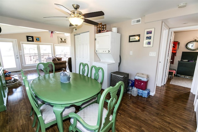 dining area with dark wood-type flooring, stacked washer / dryer, and ceiling fan