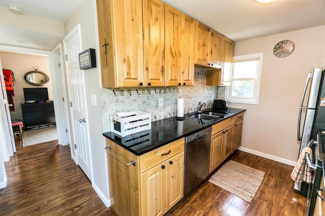 kitchen featuring sink, stainless steel dishwasher, dark hardwood / wood-style floors, dark stone countertops, and decorative backsplash