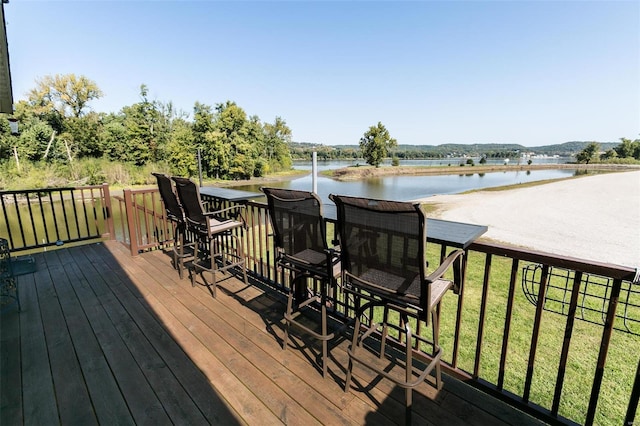 deck with a lawn and a water view